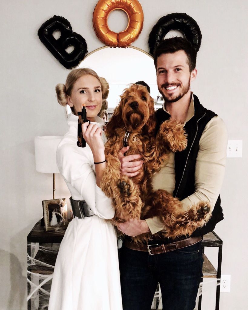 Couple and their dog dressed in Star Wars Halloween Costumes as Princess Leia, Hans Solo and Chewbacca.